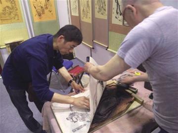 数万件工美大师精品亮相会展中心(图1) 青岛工美大师现场作画。